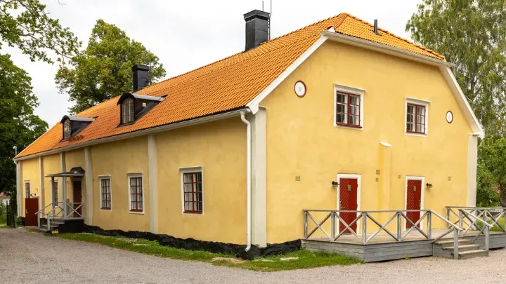 Flygeln Paradiset med gul träfasad och vita fönster.