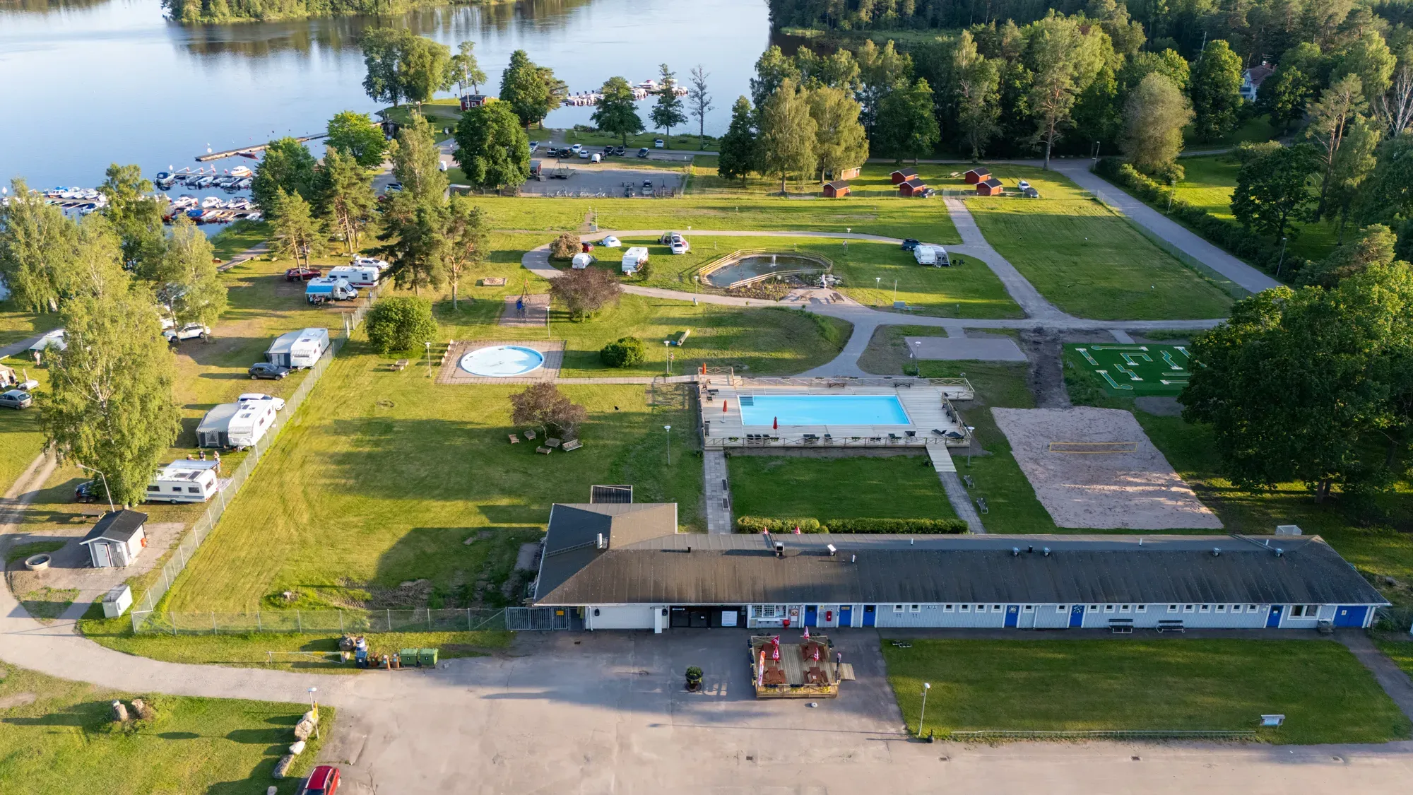 Utomhuspool och aktivitetsområde i grön miljö.