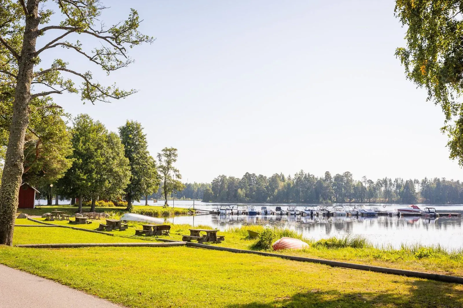 Promenadväg längs Dalälvens vatten med träd runt omkring.