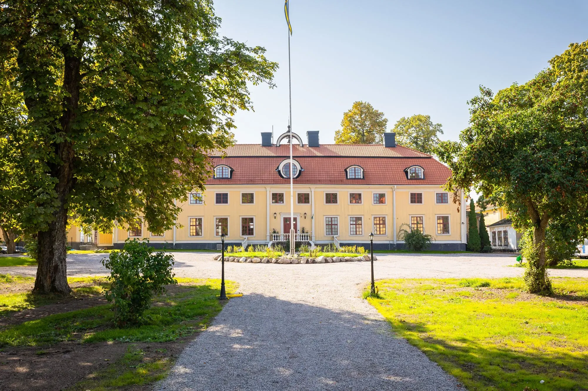 Söderfors Herrgårds huvudbyggnad och flyglar sedda från trädgården.