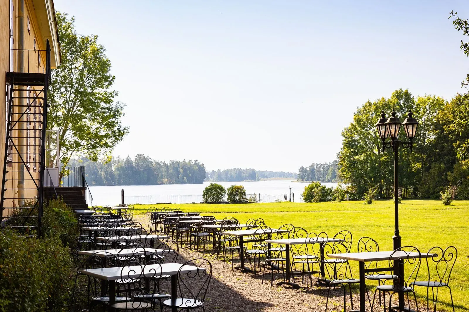Herrgårdens restaurang med dukade bord och utsikt mot älven.