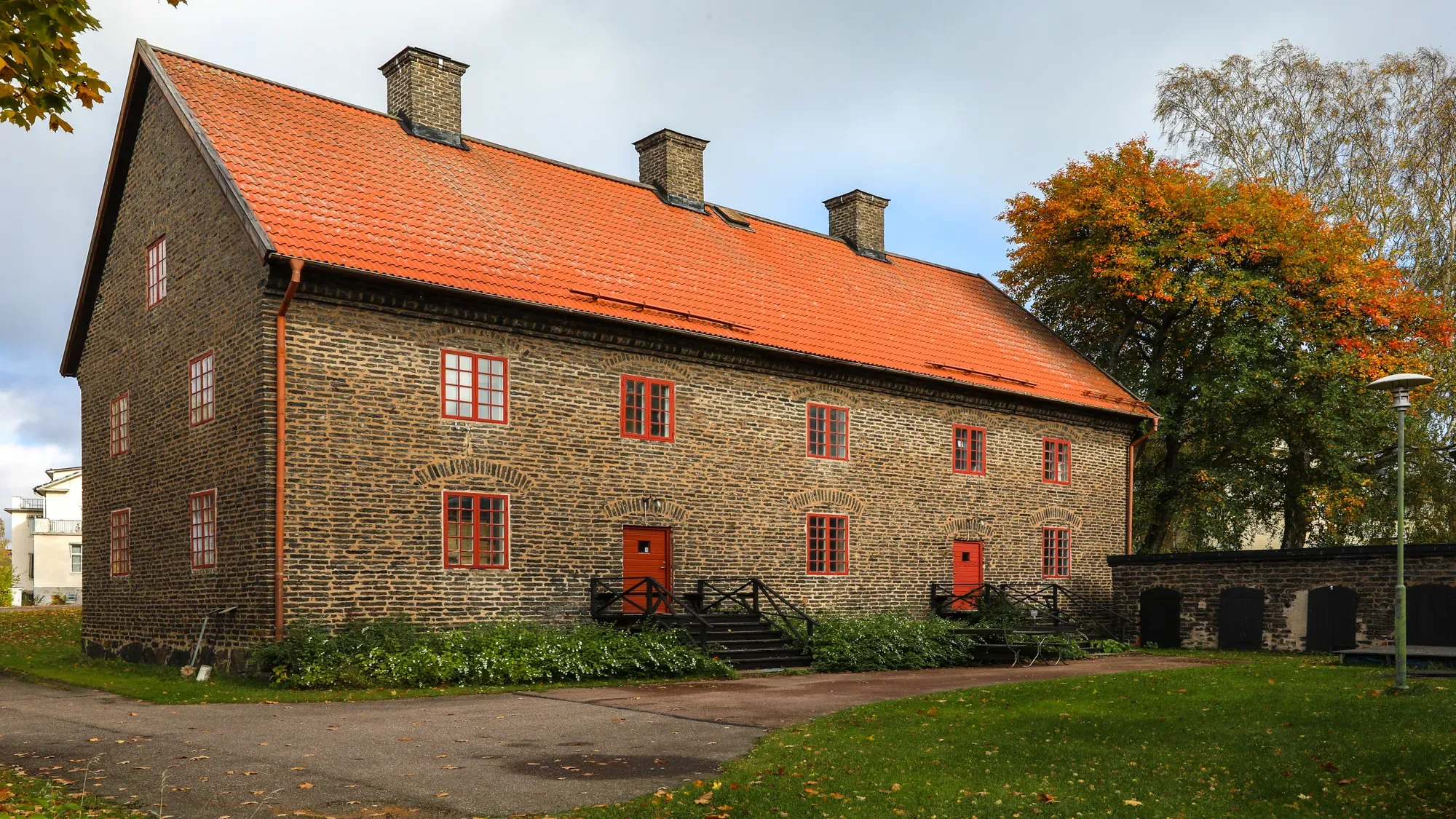 Änkehuset i Söderfors, byggt i mörkt tegel med rött tak och röda fönster.