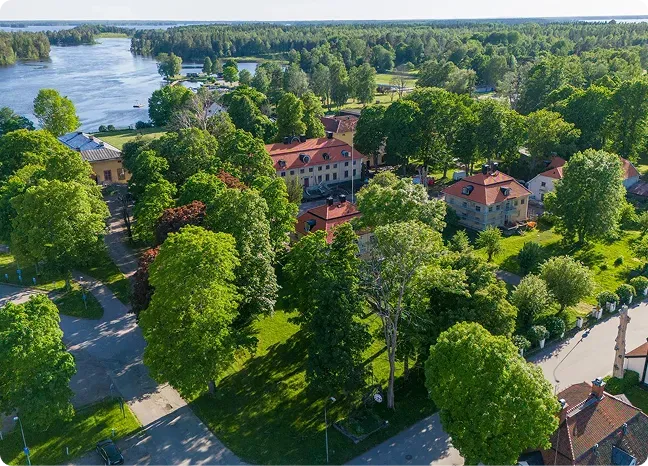 Flygbild över Söderfors Herrgård, Dalälven och den omgivande grönskan.
